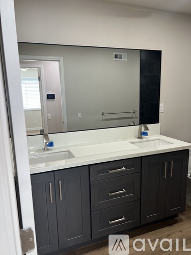 A bathroom with a sink, mirror, and cabinets.