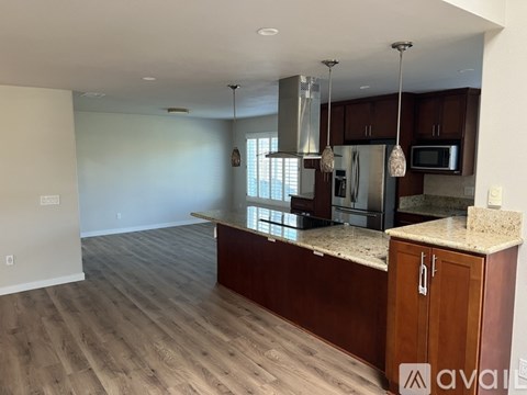 A kitchen with wooden cabinets and a granite countertop.