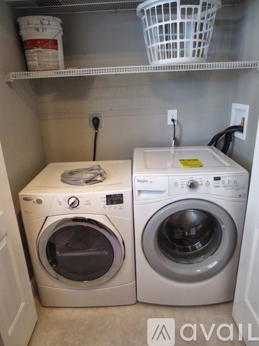 A small laundry room with two front loading washing machines.