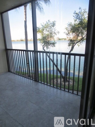 A balcony with a view of a body of water and trees.