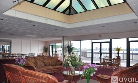A living room with a couch, chairs, and a table with flowers.