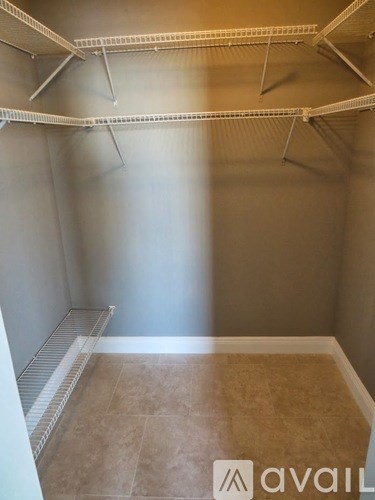 A room with a tiled floor and a wall with a shelf above it.