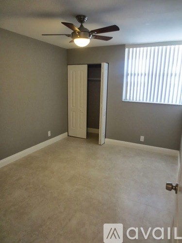 A room with a ceiling fan and a door.