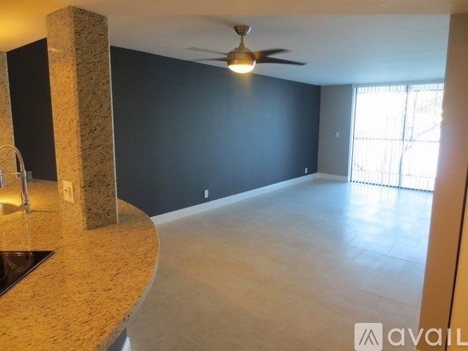 A room with a ceiling fan and a counter with a sink.