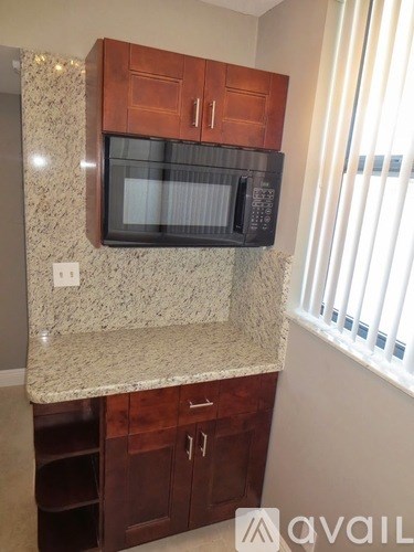 A kitchen with granite countertops and wooden cabinets.