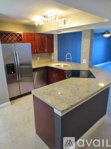 A kitchen with a granite countertop and stainless steel appliances.