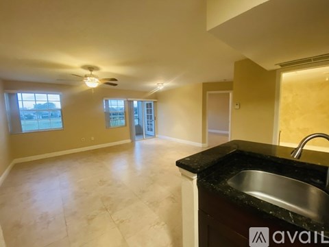 A kitchen area with a sink and a fan.