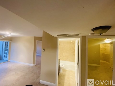 A room with a ceiling fan and a door leading to another room.