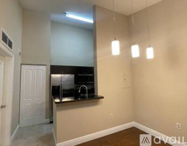A kitchen area with a sink and a refrigerator.