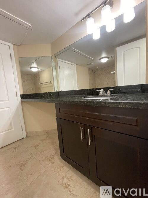 A bathroom with a marble countertop and a large mirror.