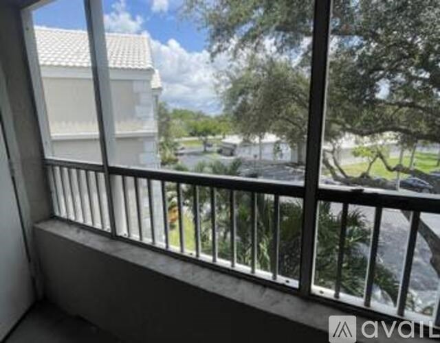 A balcony with a view of a park and a building.