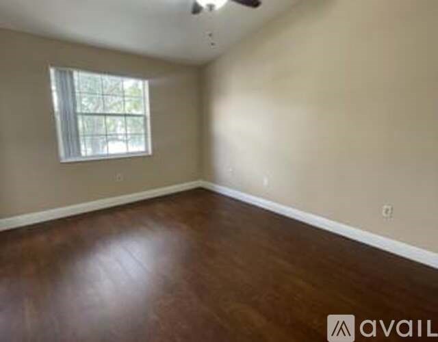 A room with wooden flooring and a window.