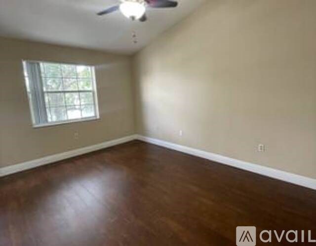 A room with a ceiling fan and a window.