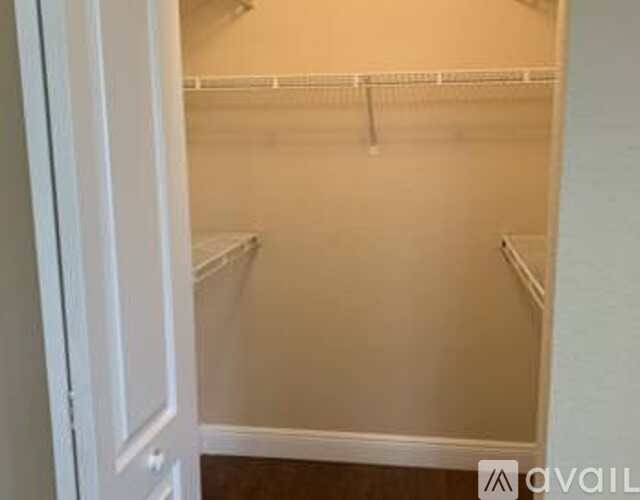 A white closet with a door open and no items in it.