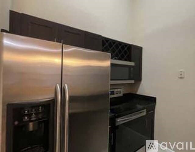 A stainless steel refrigerator with its door open in a kitchen.
