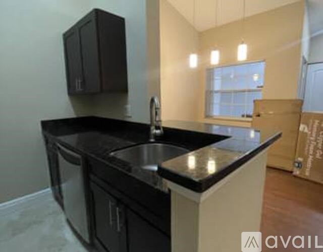 A kitchen with black countertops and a sink.