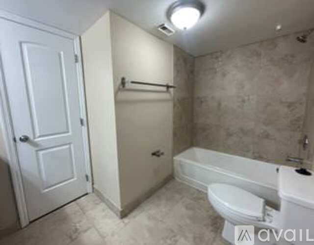 A bathroom with a toilet, tub, and towel rack.