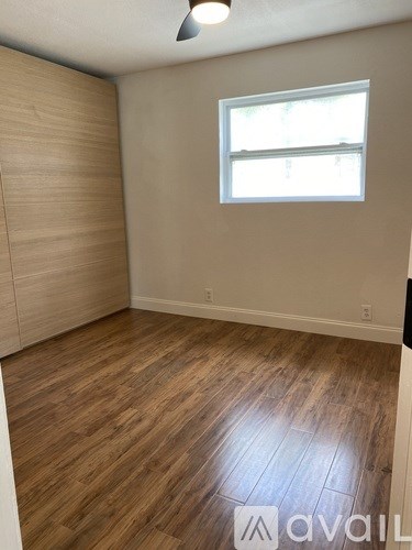 A room with wooden flooring and a window.