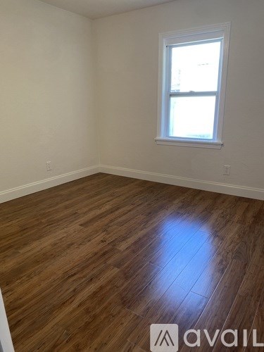 A room with wooden flooring and a window.