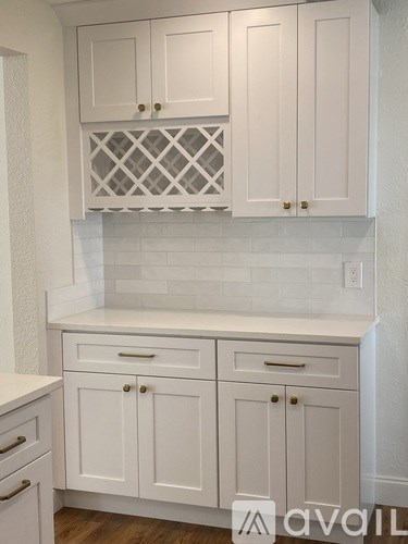 A kitchen with white cabinets and a white subway tile backsplash.