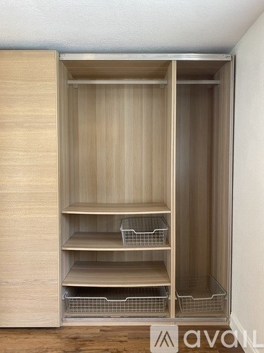 A wooden pantry with shelves and baskets is open.