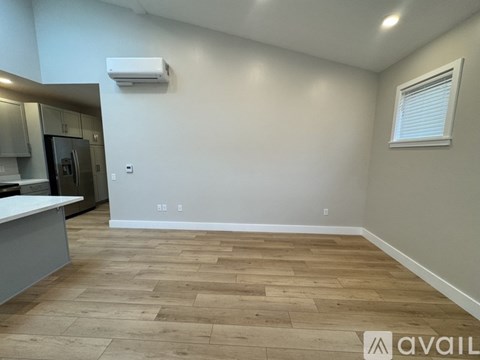 A room with wooden flooring and a window with blinds.