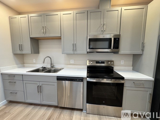 A kitchen with stainless steel appliances and white cabinets.