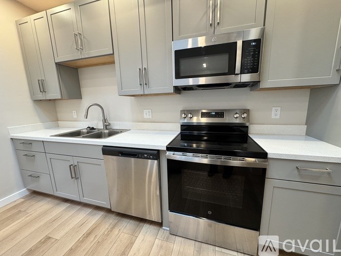 A kitchen with a stainless steel oven and microwave above it.