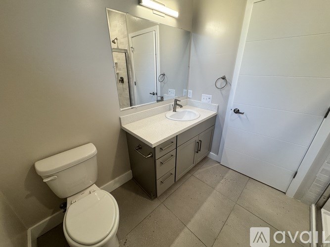 A bathroom with a toilet, sink, and mirror.