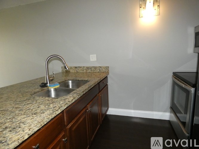 A kitchen with granite countertops and wooden cabinets.