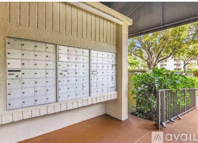 A row of mailboxes on a wall outside a building.