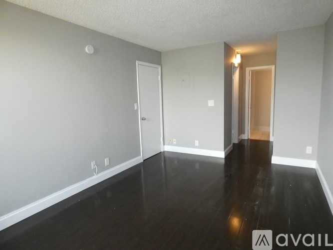 A room with a wooden floor and two doors.