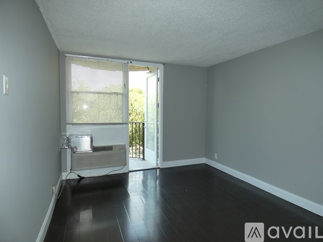 A room with a sliding glass door leading to a balcony.