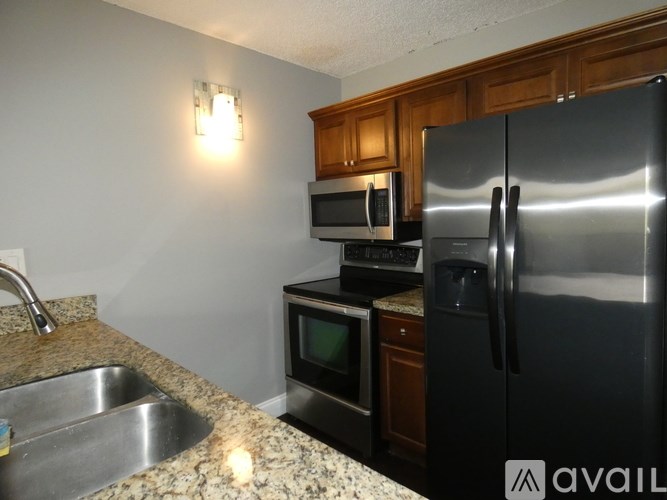 A kitchen with a granite countertop and stainless steel appliances.