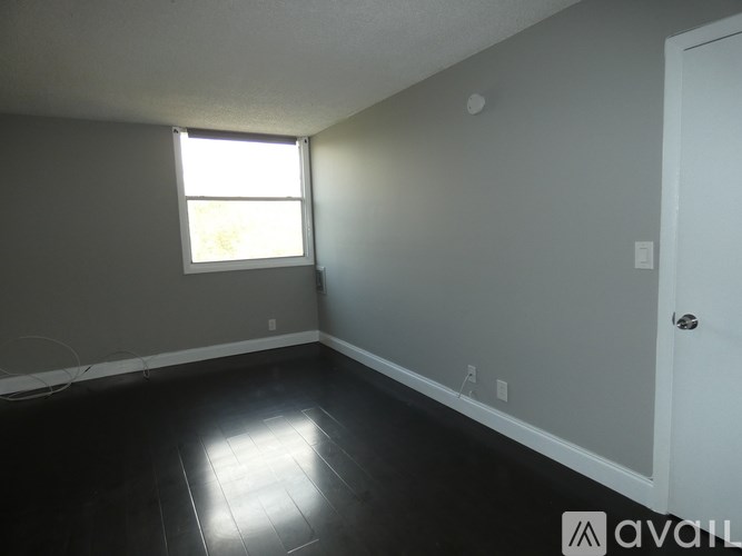 A room with a white door and a window with sunlight coming through.