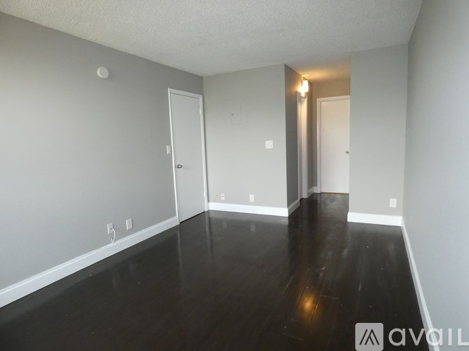 A room with wooden floors and two doors.