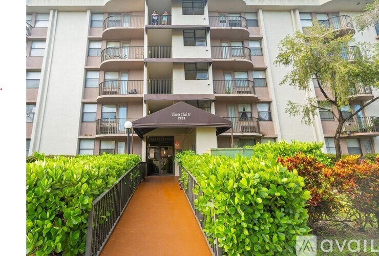 A building with a brown awning and a walkway leading to it.