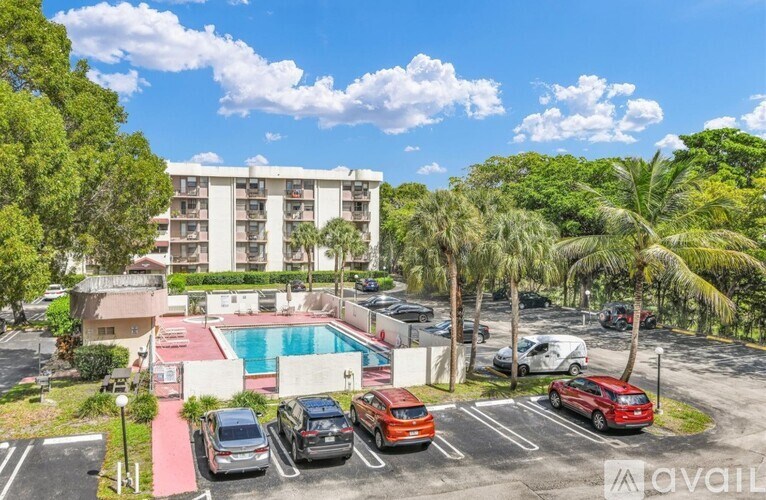 A sunny day at the apartment complex with cars parked in the lot.