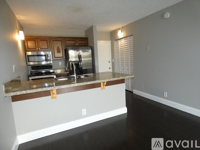 A kitchen with a granite countertop and stainless steel appliances.