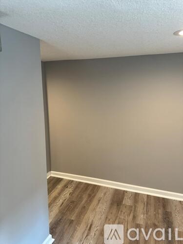 A room with wooden flooring and a wall with a logo that reads "avaiL".
