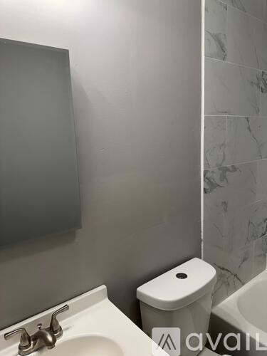 A white toilet sits next to a sink in a bathroom.