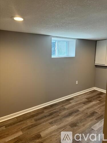 A room with wooden flooring and a window.