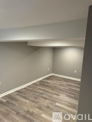 A room with wooden flooring and a wall with a logo that reads "avaiL".
