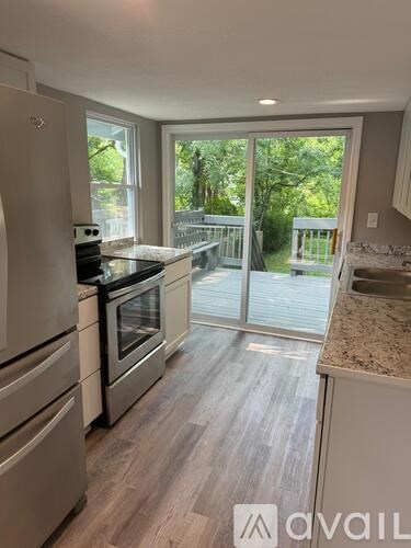 A kitchen with a refrigerator, oven, and countertops.