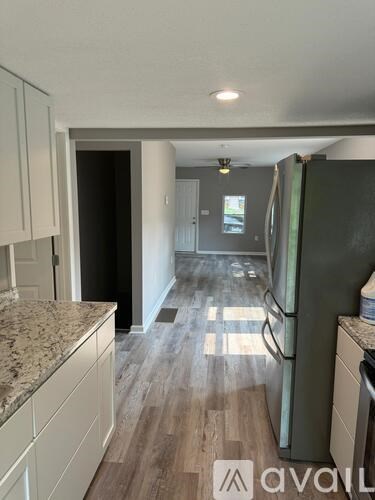 A kitchen with a granite countertop and a refrigerator.