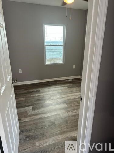 A room with a window and a fan.