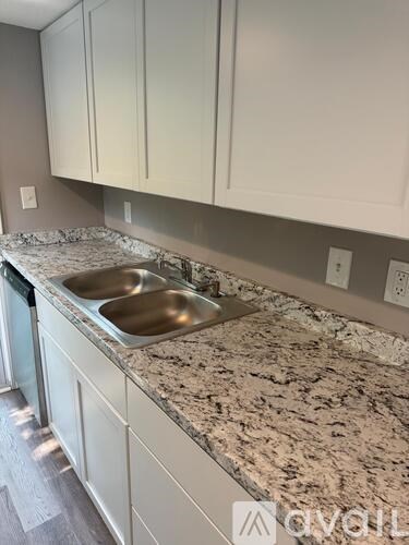 A kitchen with a granite countertop and white cabinets.