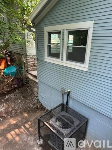 A small window on a house with a grill in front of it.