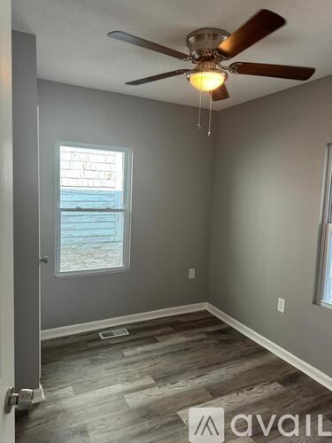 A room with a ceiling fan and a window.