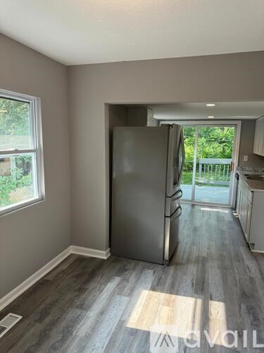 A kitchen with a refrigerator and a window.